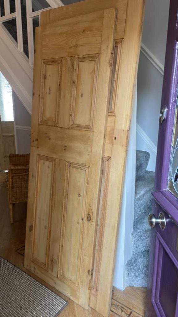 Professional paint stripping of a wooden door in Mold, removing old layers to restore natural wood